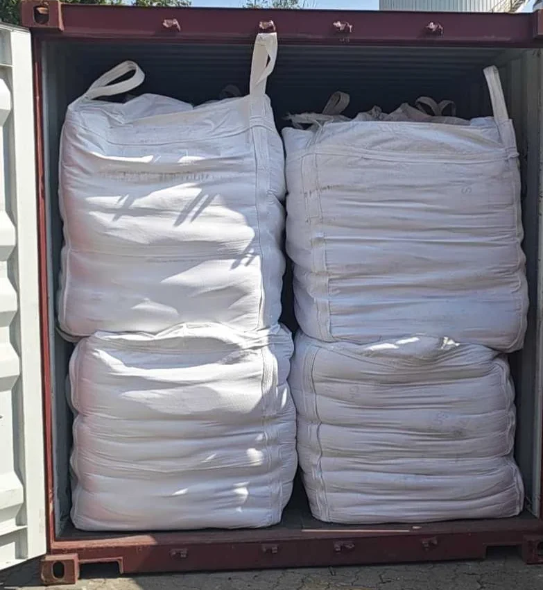 Flexible intermediate bulk containers (FIBC jumbo bags) of fused silica stacked inside the second export container after loading, seen through the open container doors.